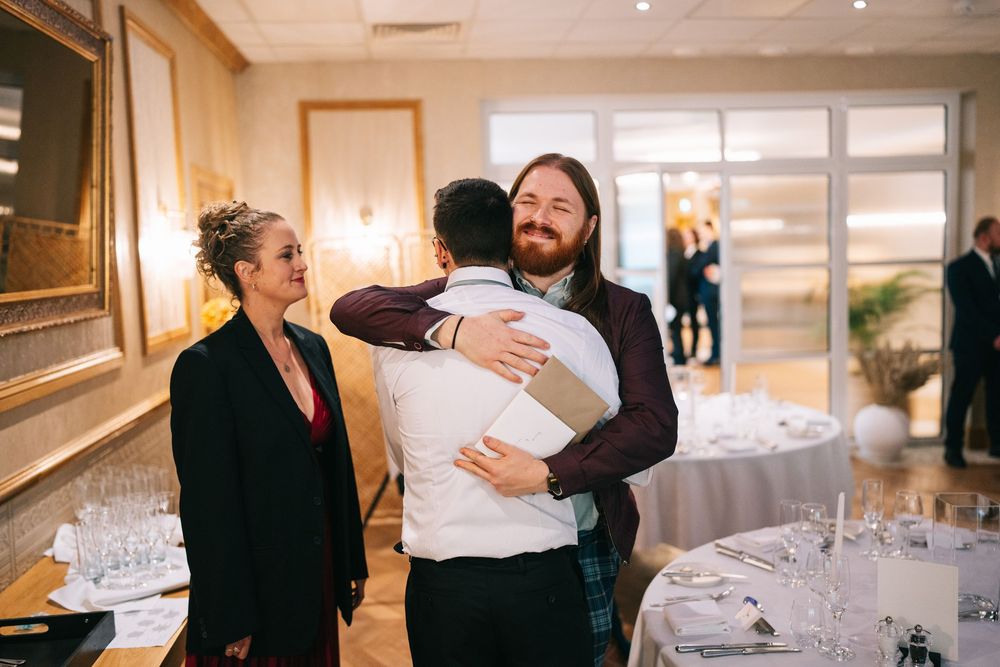 People embrace and celebrate during a joyful wedding reception in an elegant ballroom setting.