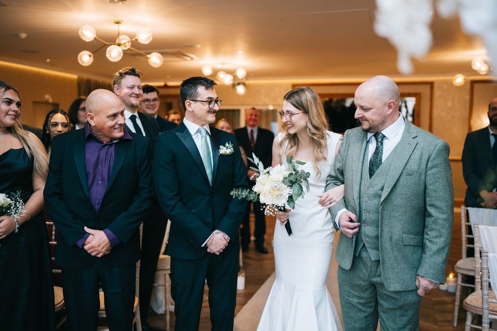 Wedding reception guests dancing and celebrating together in an elegant ballroom with warm lighting.