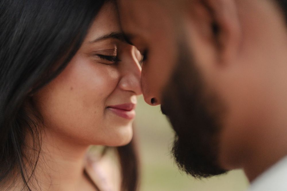 Close-up romantic portrait of couple sharing an intimate moment in warm lighting.