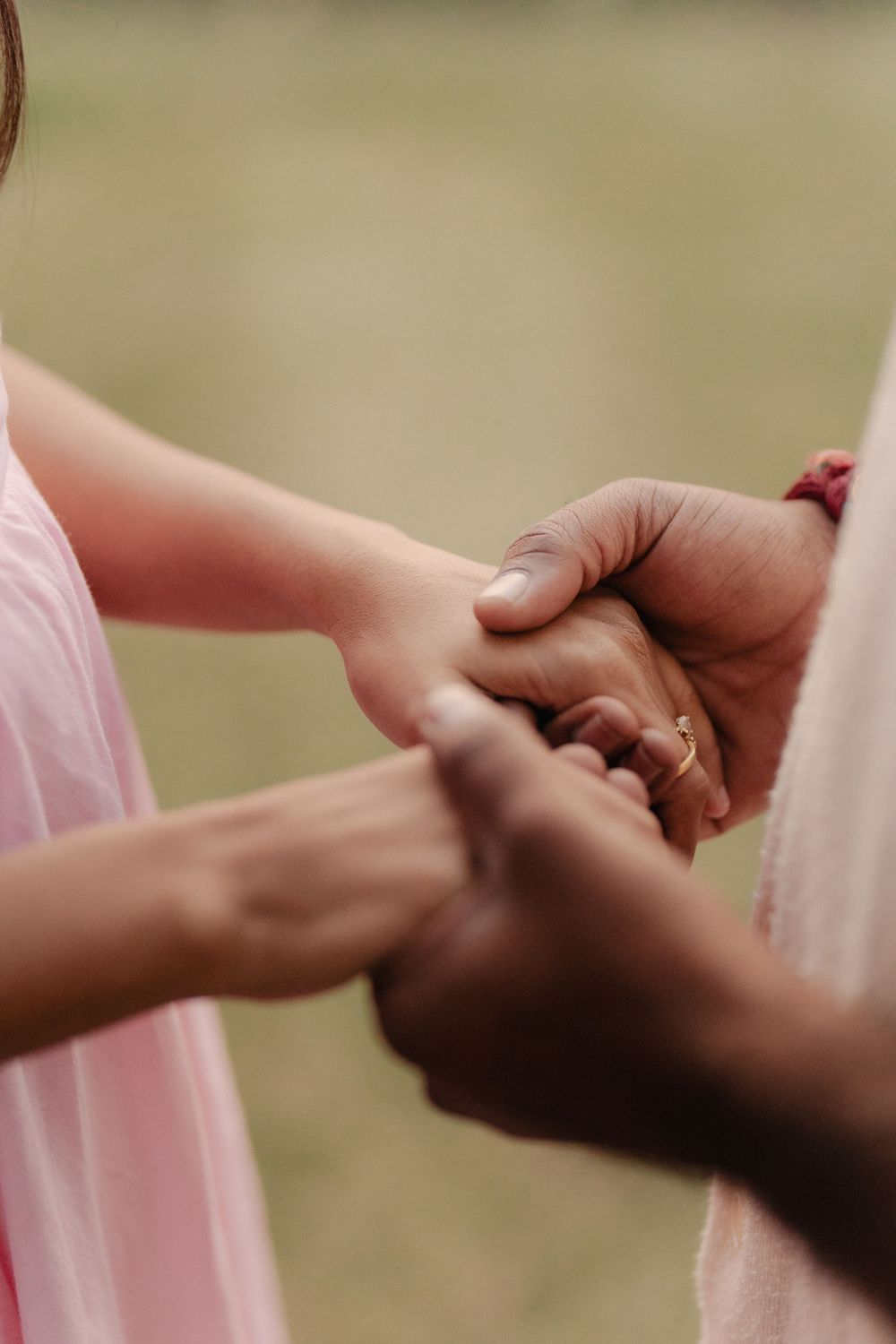Close-up view of hands exchanging wedding rings during a romantic ceremony in soft lighting.