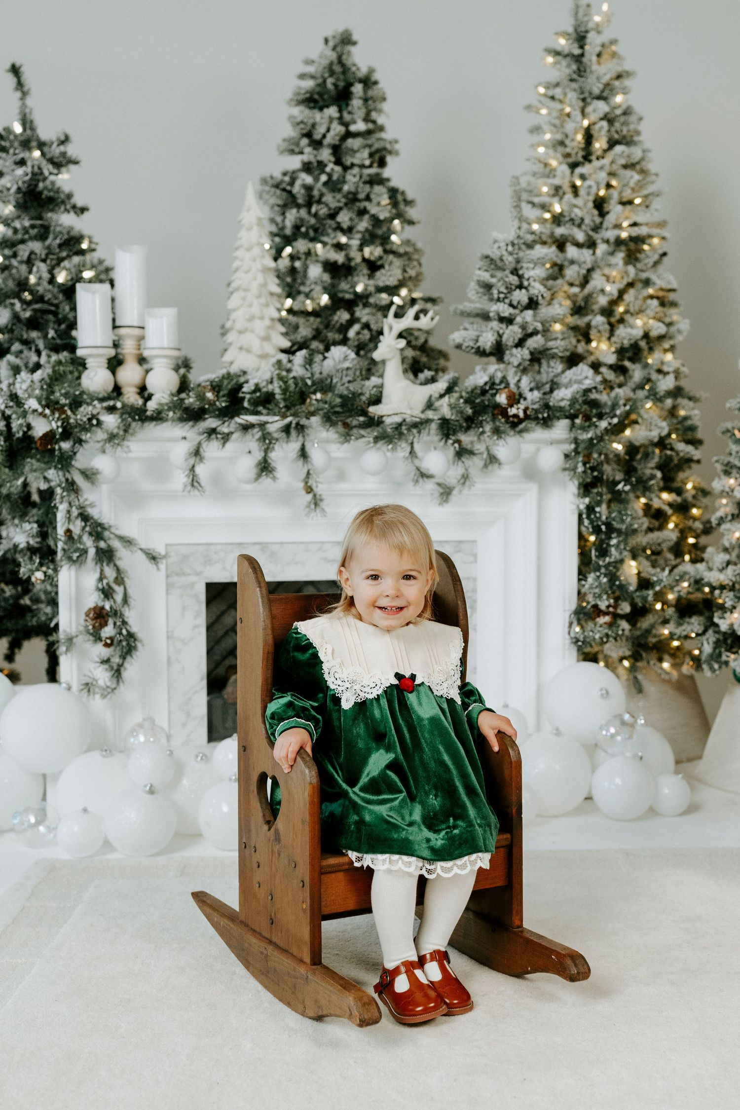 A festive holiday scene with decorated Christmas trees and a white mantle with stockings and candles.