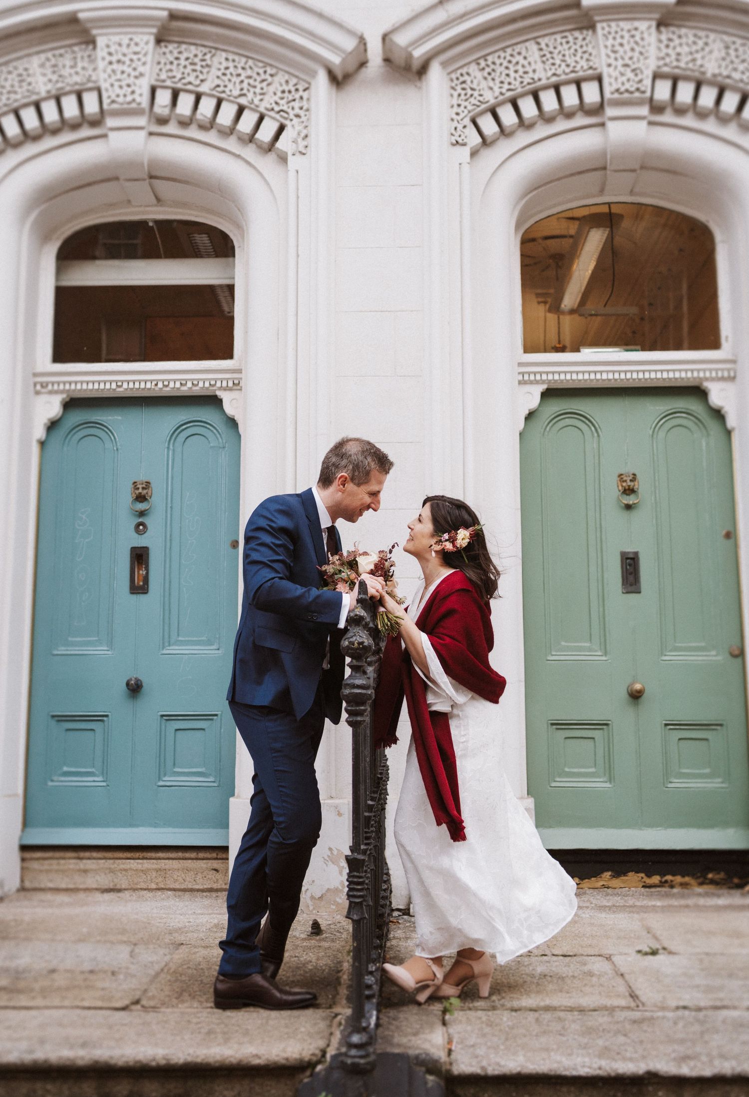 A romantic sequence of five photos showing a couple sharing intimate moments against turquoise doors in an elegant hallway.