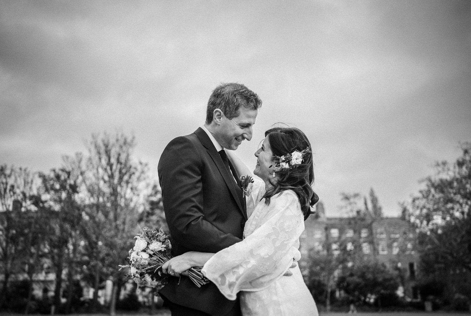 A romantic black and white wedding photo series showing intimate moments between newlyweds in an outdoor setting.
