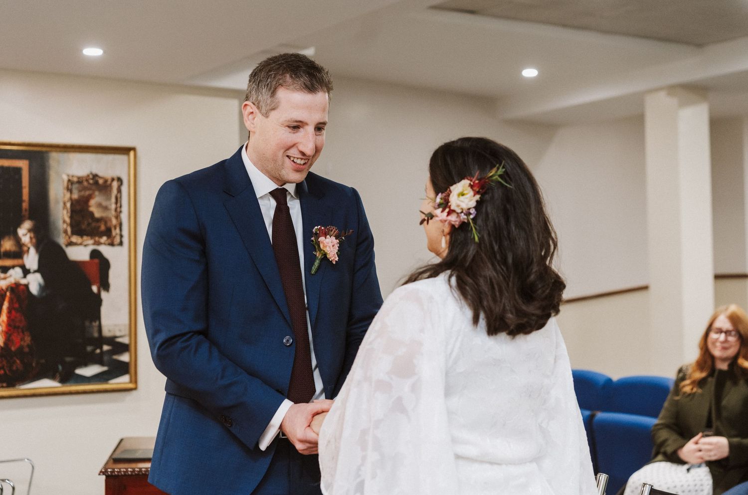 A couple in formal wedding attire shares a joyful moment while dancing together at a reception.
