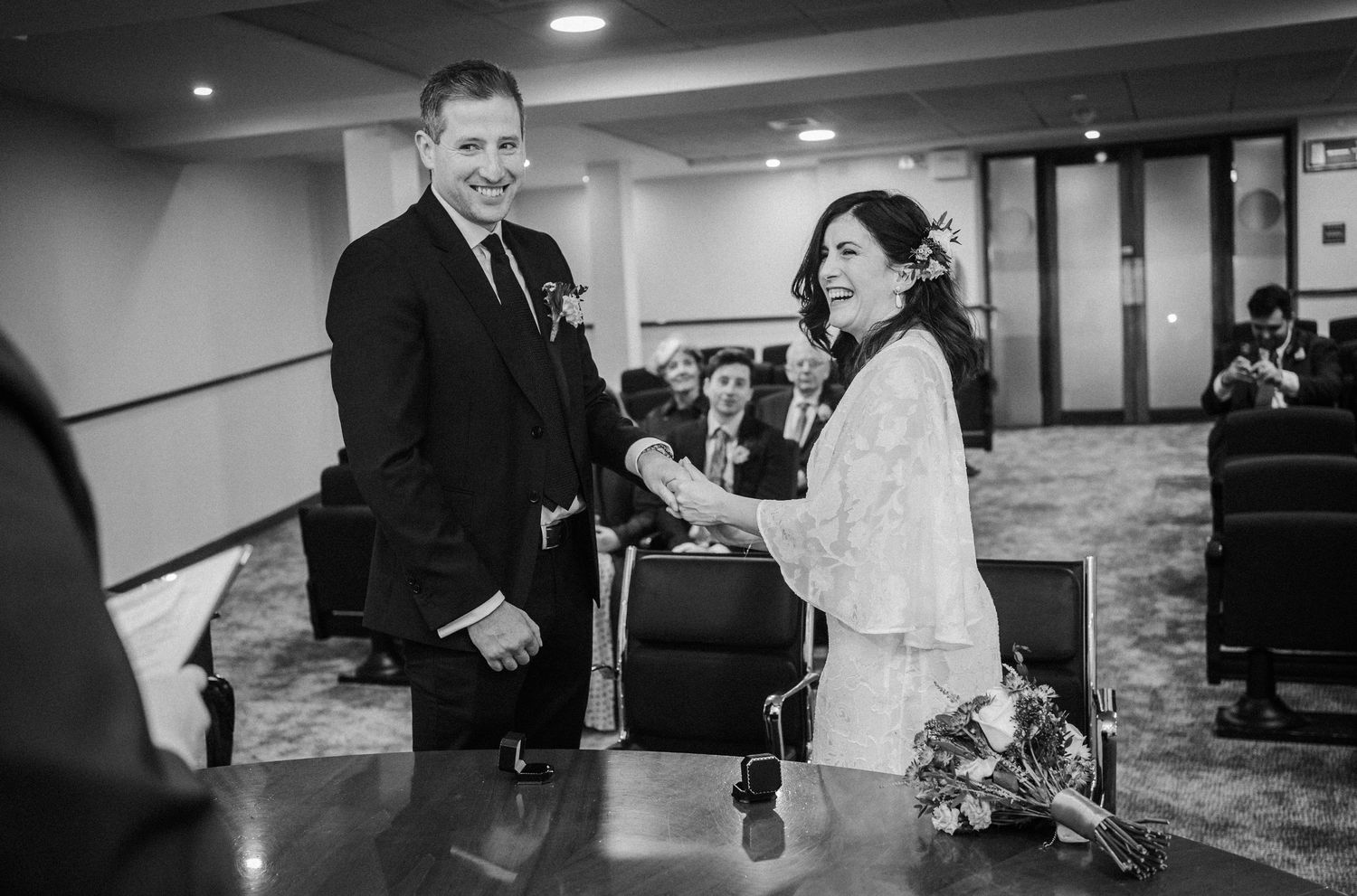 A wedding couple shares intimate moments during their reception celebration in a dimly lit venue.