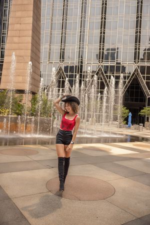 A sequence of dance movements captured in six frames showing a person in red and black attire performing near a building exterior.
