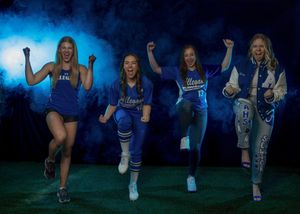 Four people in blue athletic wear jumping and posing against a dark background with blue lighting effects.