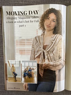 Magazine spread featuring dance photography and fashion editorial with beige knit sweater and dark pants styling.