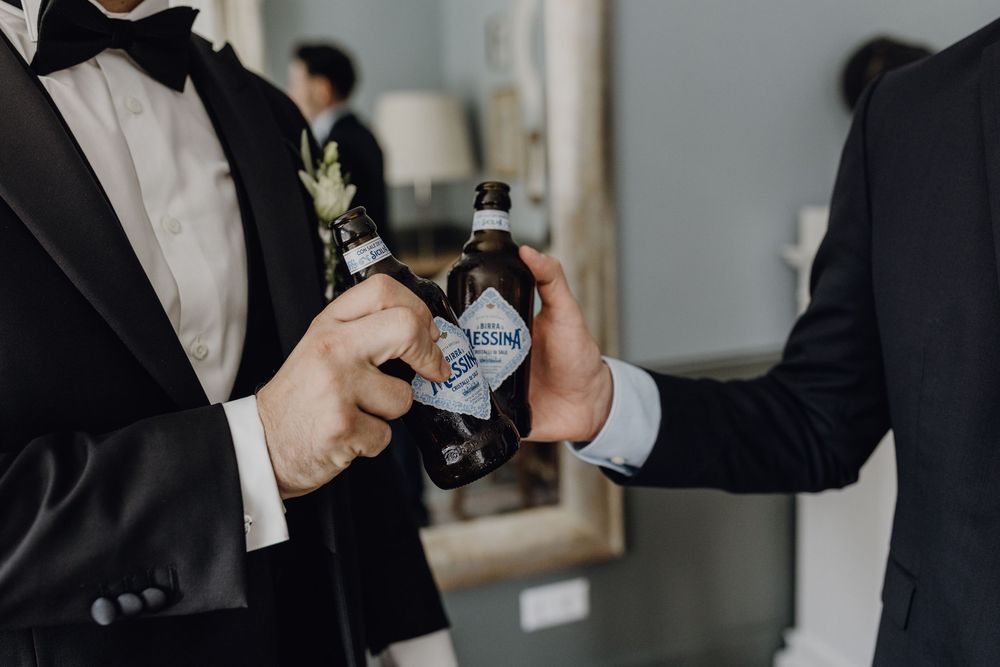 Getting Ready am Hochzeitstag - der Bräutigam stößt mit seinem Trauzeugen mit Bier an.