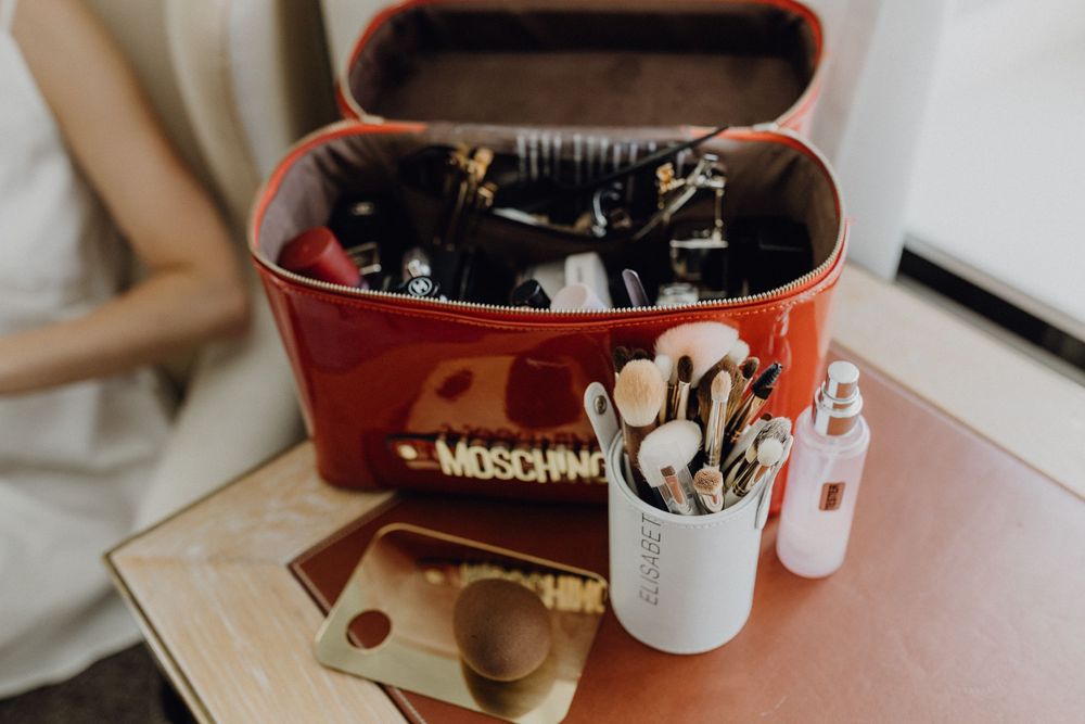 Getting Ready am Hochzeitstag - man sieht den roten Schminkkoffer mit vielen Pinseln.