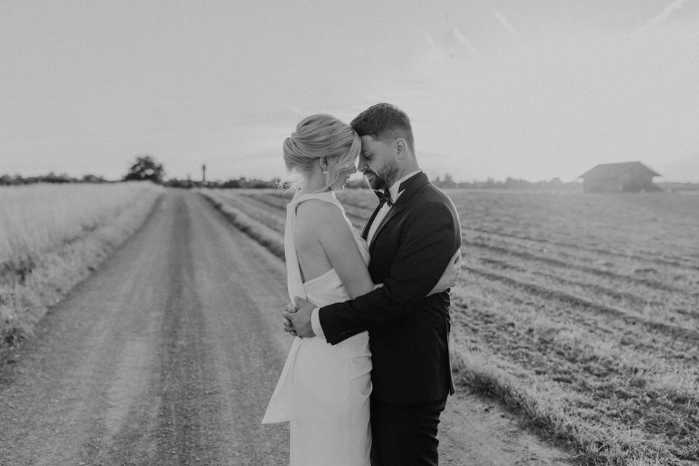 Paarshooting am Hochzeitstag bei Sonnenuntergang, das Paar hält sich im Arm und genießt den Moment.