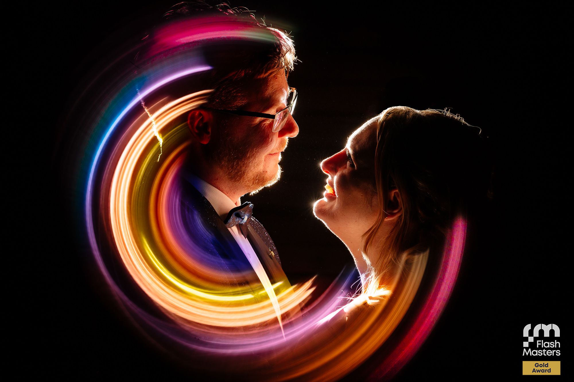 Creative long exposure photography creating colorful light trails against black background.