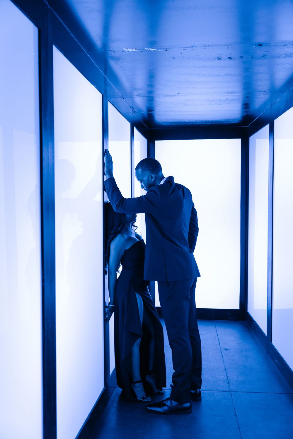 Silhouettes of people in a dimly lit blue corridor creating a dramatic sequence of interactions.