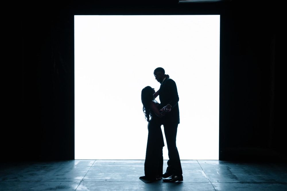 A series of black and white silhouettes show two figures embracing in a minimalist, artistic composition.