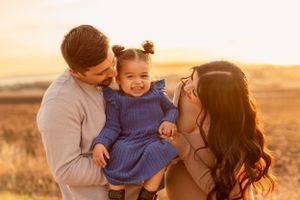 A family shares a tender moment together during golden hour in a rural setting.
