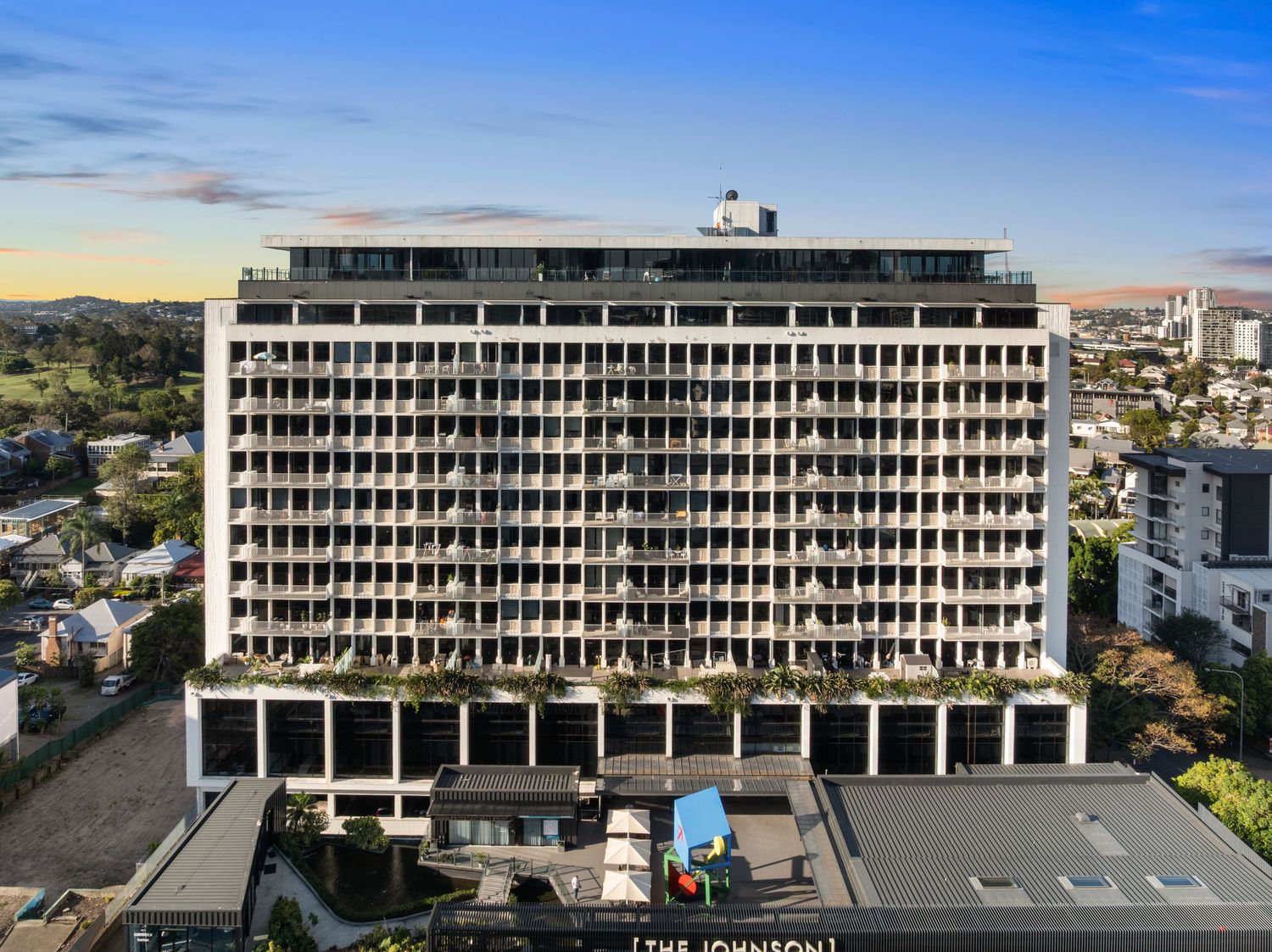 Modern commercial building exterior with repetitive geometric patterns and concrete facade.