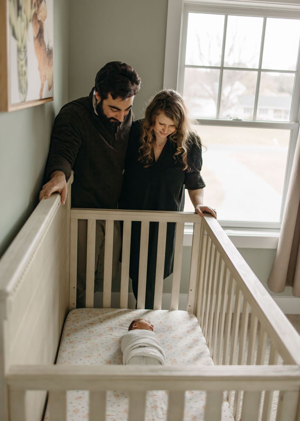 A sequence of photos showing a baby being placed into a white crib while someone watches from above.