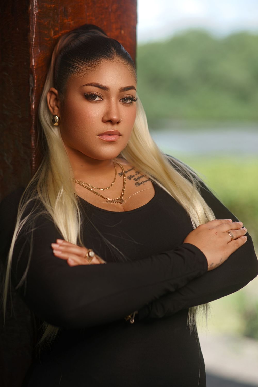 Stylish portrait series featuring poses in a black long-sleeved dress with natural outdoor lighting.