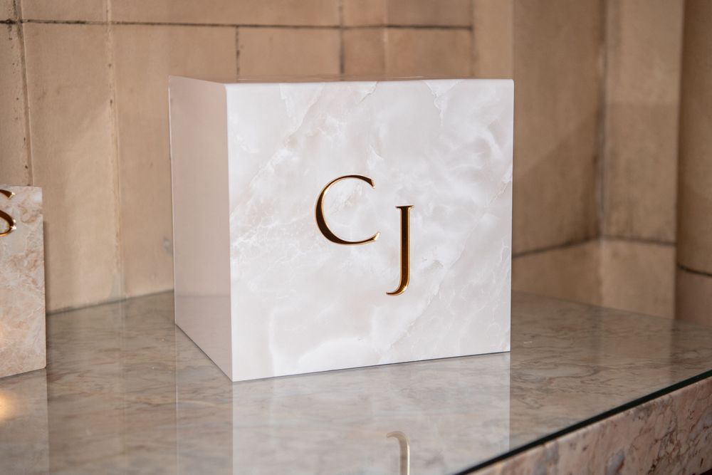 Minimalist white marble box with gold monogram initials CJ.