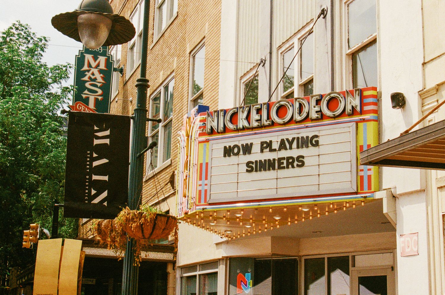 Vintage movie theater marquees and facades shown in a series of connected photographs from different angles and times of day.