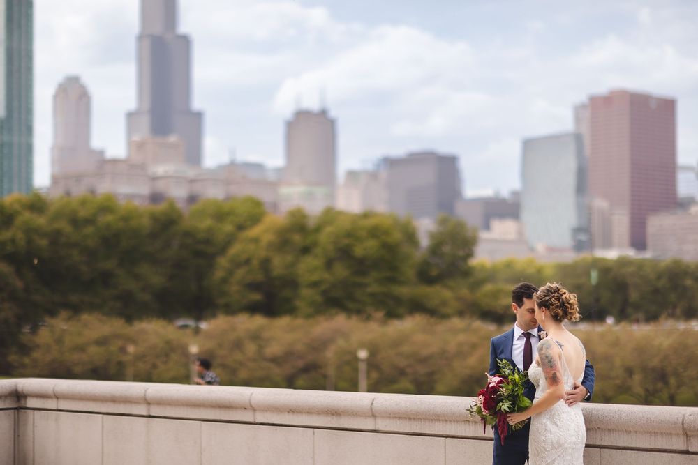 A wedding couple embraces in a romantic moment against a backdrop of Central Park and the Manhattan skyline.