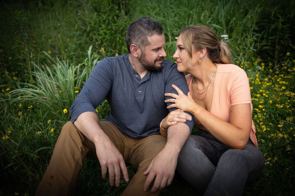 Intimate outdoor engagement photos taken in lush green garden setting.