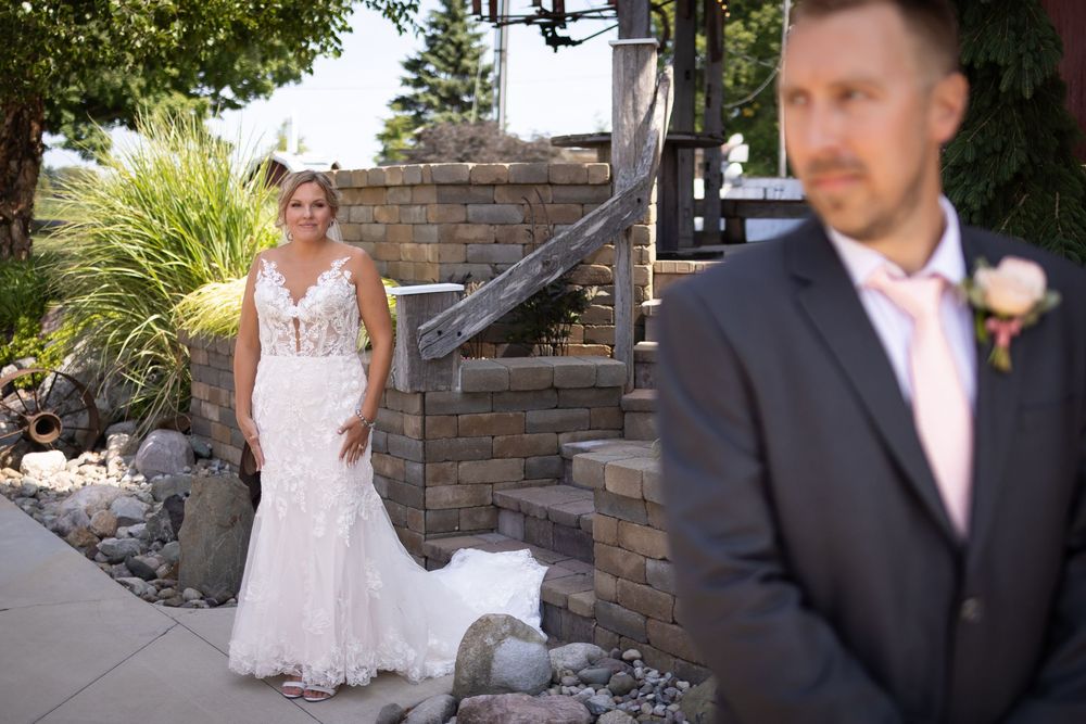 Wedding party photos taken at stone-walled venue with lush garden landscaping.