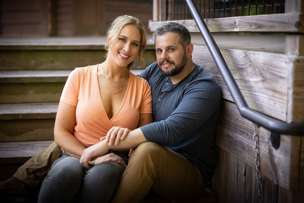 Casual engagement session on rustic wooden porch steps.