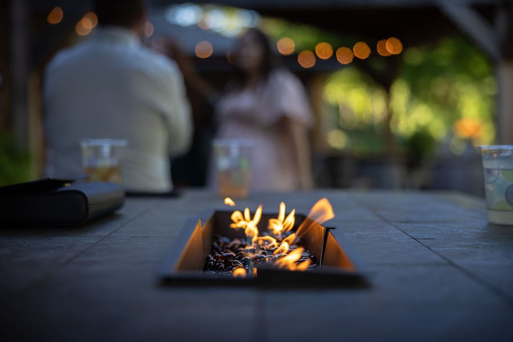 Close-up of flickering flames in an outdoor fire pit during evening wedding reception.