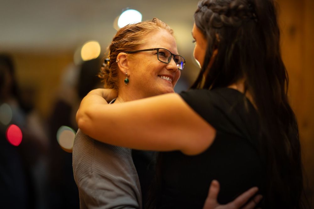 Wedding party members share joyful moments in warm lighting during preparation time.
