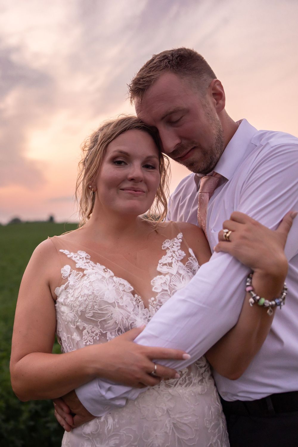 Couple shares an intimate moment at sunset during their wedding celebration.
