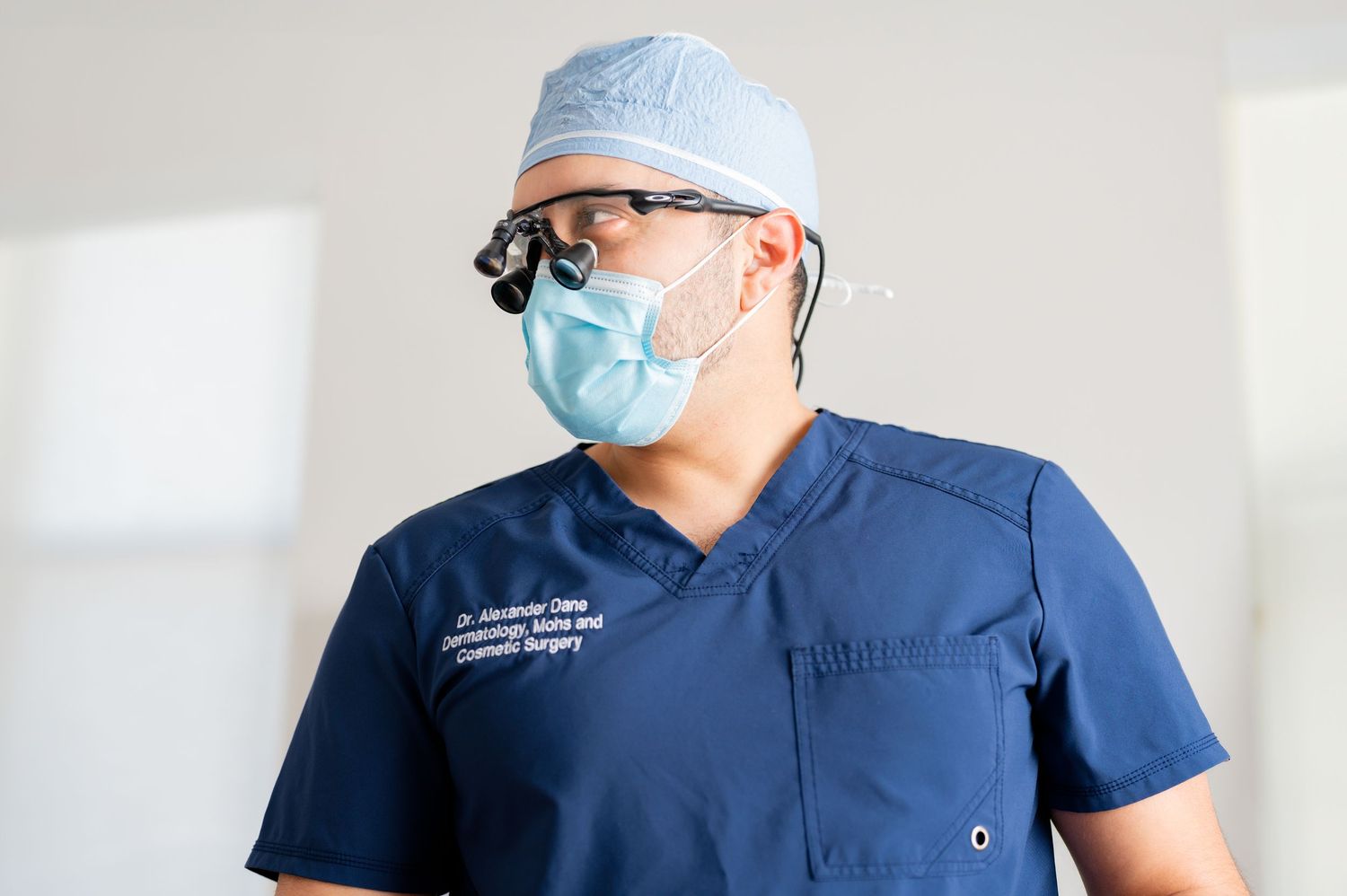 Medical professionals in blue scrubs and surgical masks working in a bright modern healthcare setting.