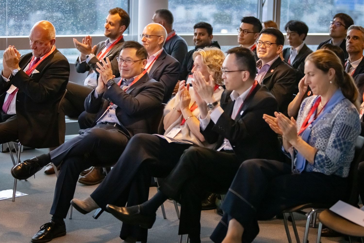 Business audience seated in rows during a professional conference presentation.
