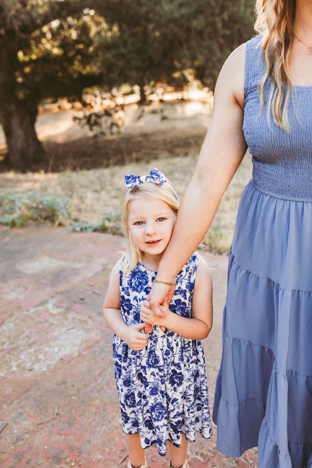 A series of photos showing a child in a blue and white floral dress next to someone in a chambray dress.