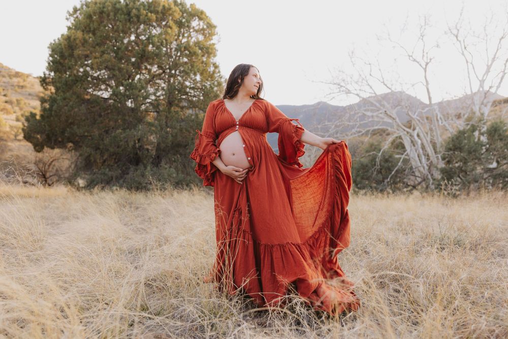 Elegant red dress photoshoot with dynamic movement in nature.