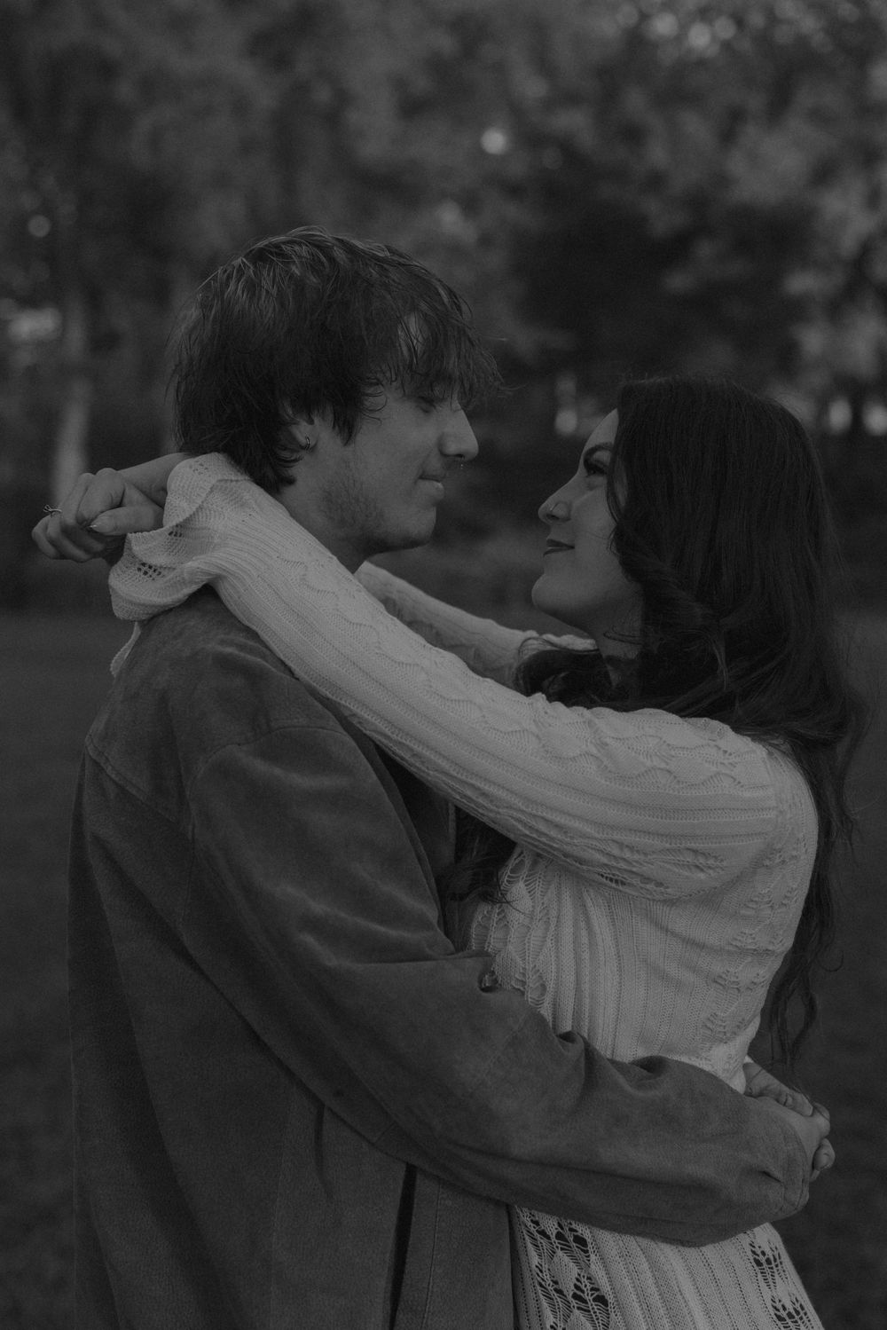 A romantic black and white sequence shows a couple embracing and dancing together in a tender moment outdoors.