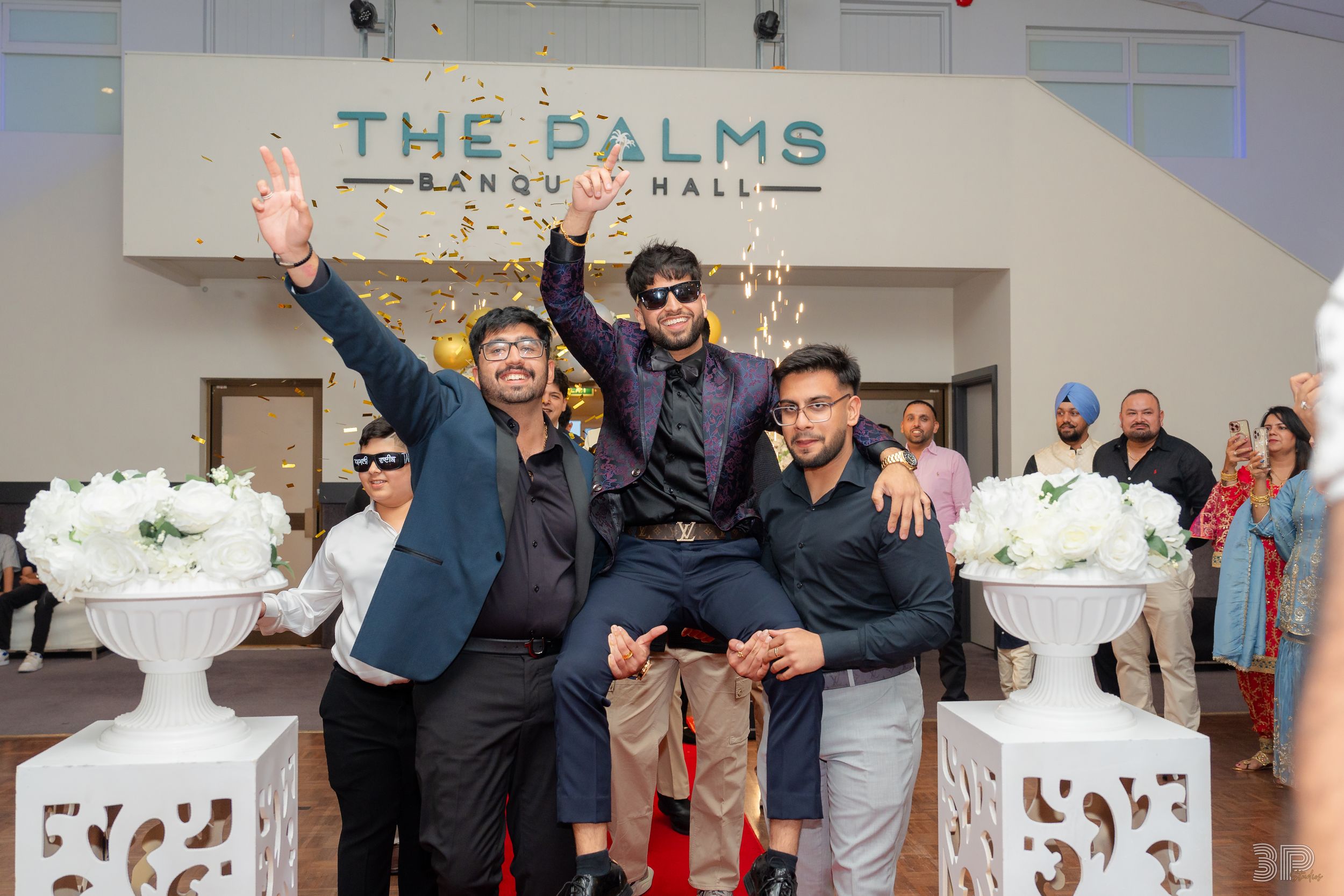 Wedding guests dancing and celebrating together on a dance floor at The Palms venue during a reception party.