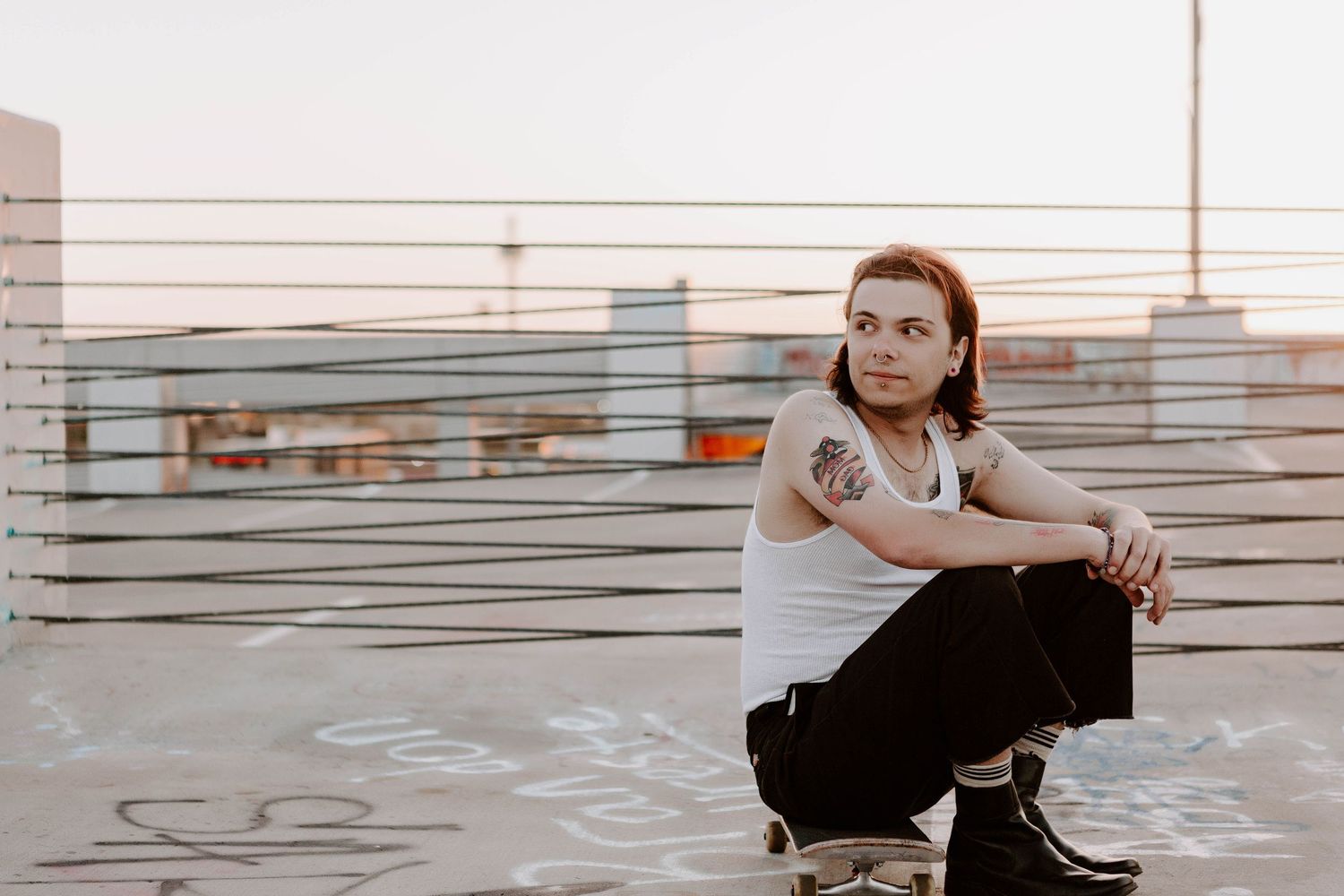 A solo session of a senior high school student in Lubbock Texas sitting on his skateboard at sunset