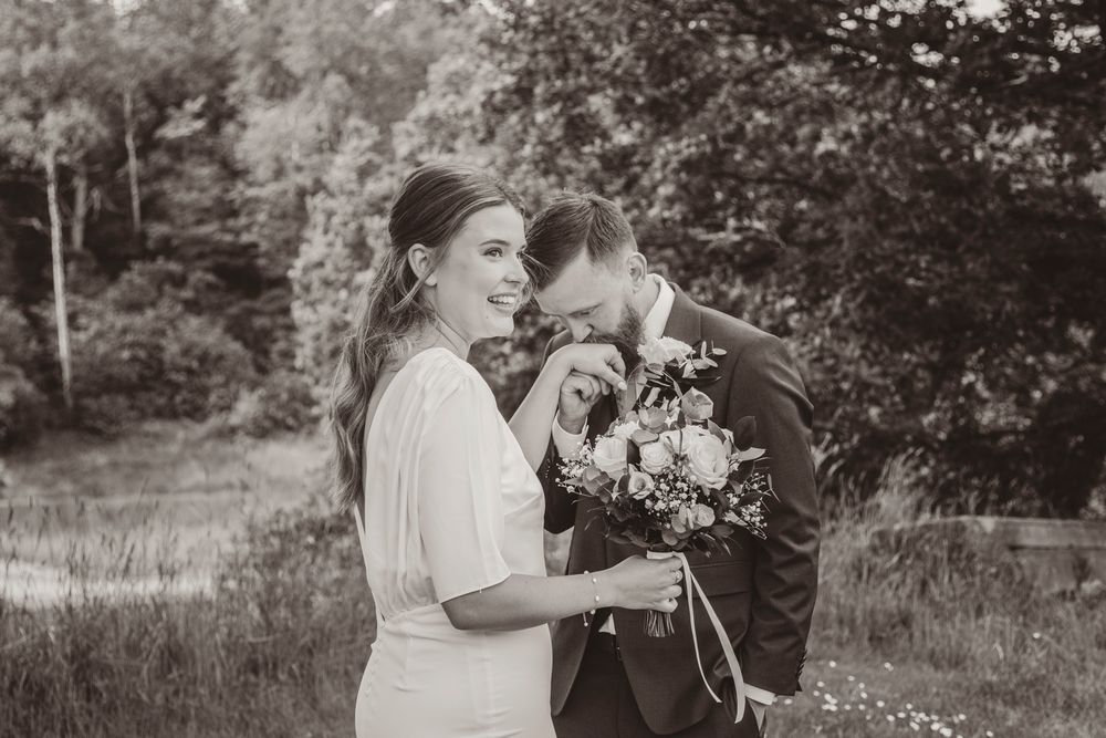 Black and white wedding photos showing intimate moments between a couple in an outdoor garden setting.