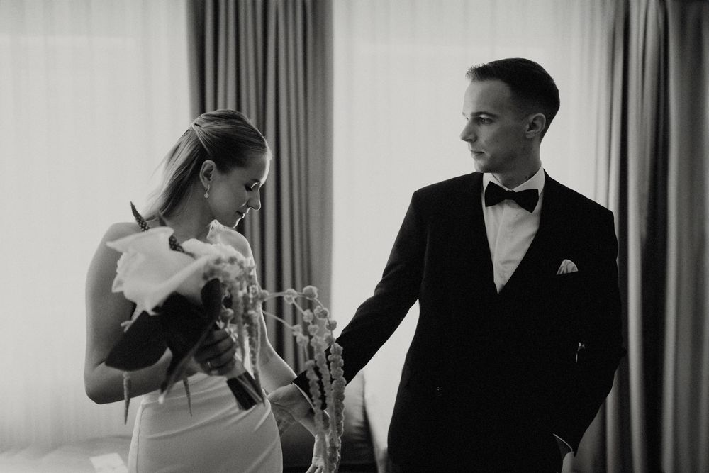 Intimate black and white portrait of couple sharing romantic moment in formal attire.