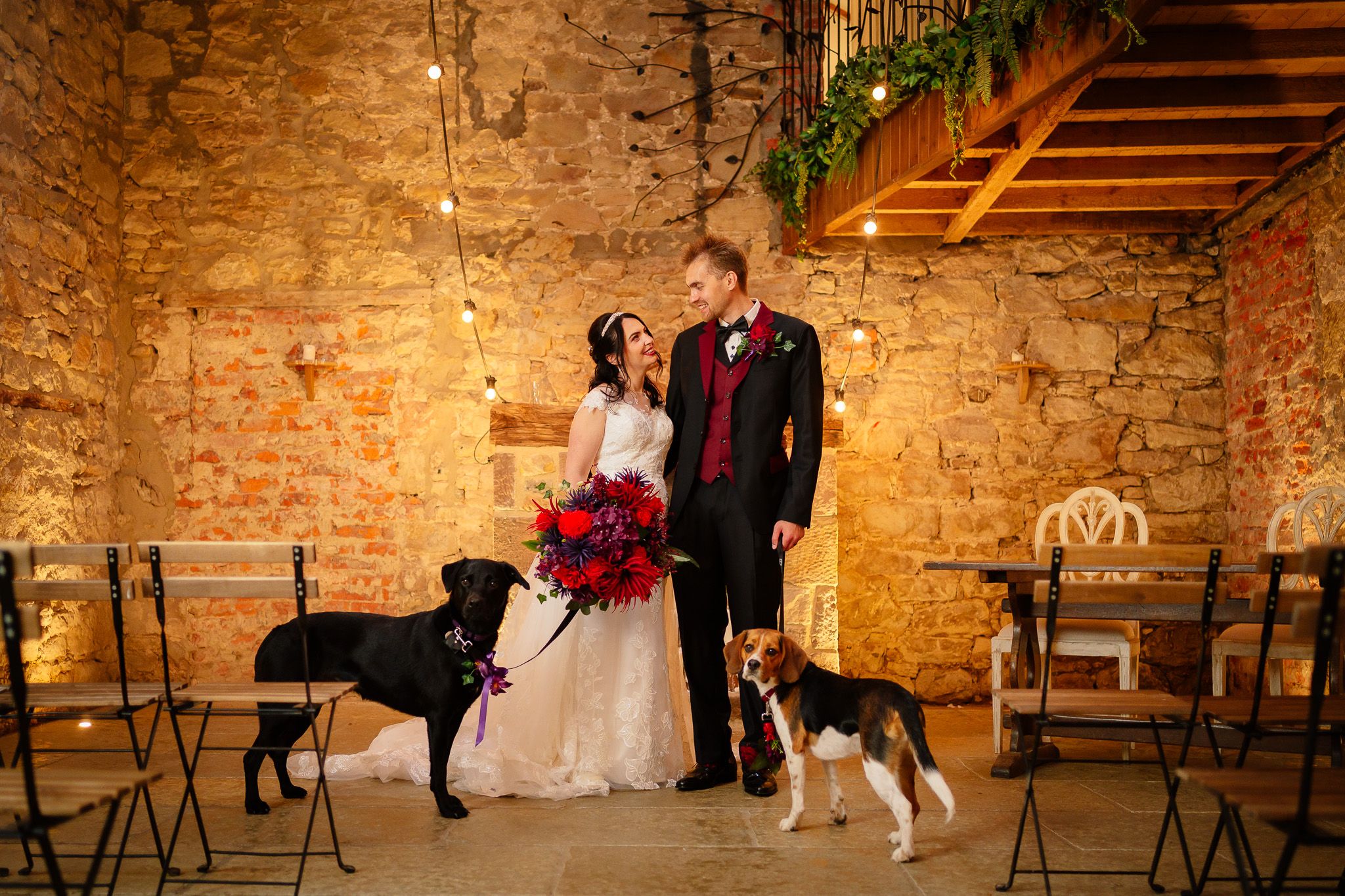 Interior of rustic stone barn venue with wooden beams and ambient lighting. Doxford Barns