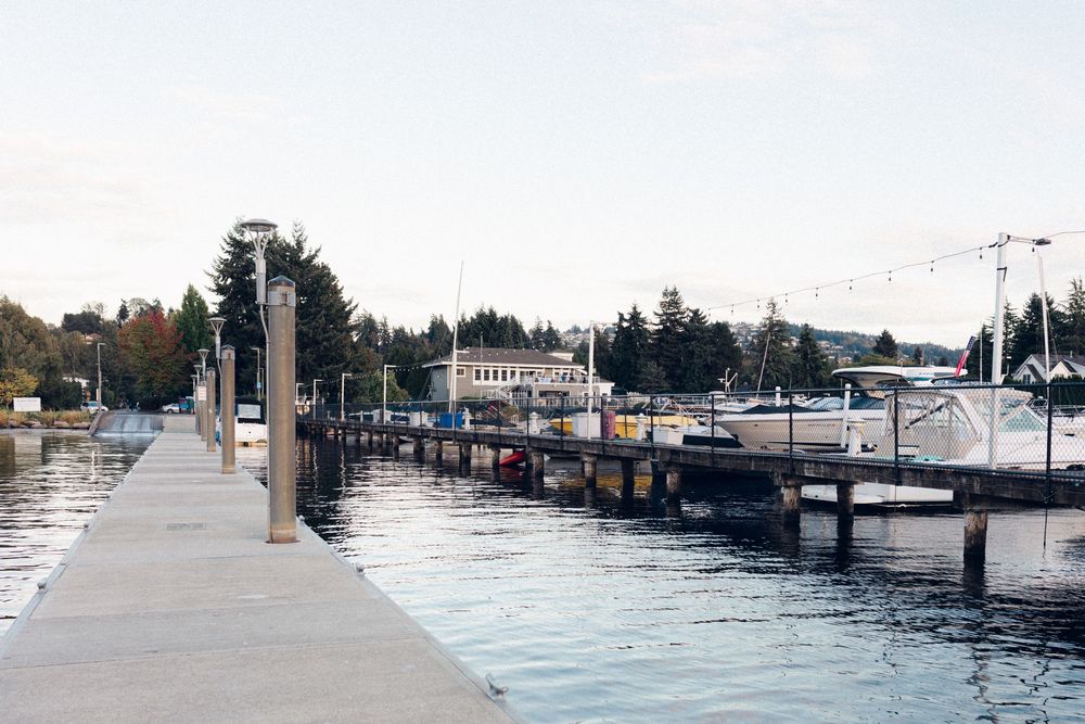 A panoramic view of a marina with boats docked along wooden piers on a cloudy day.