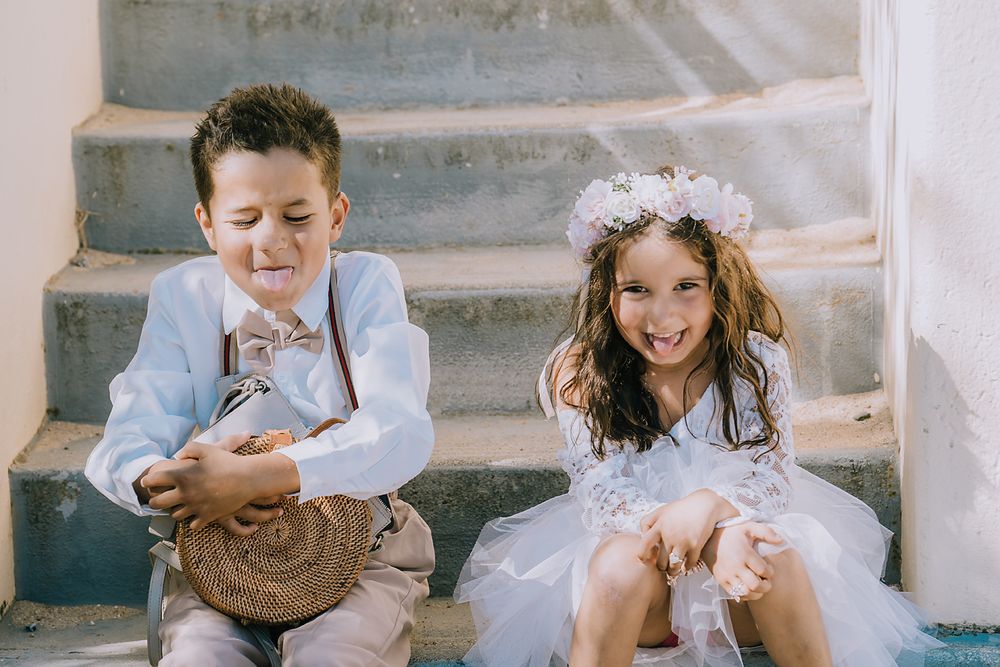 Candid black and white photos of wedding party members laughing and having fun on stone steps.