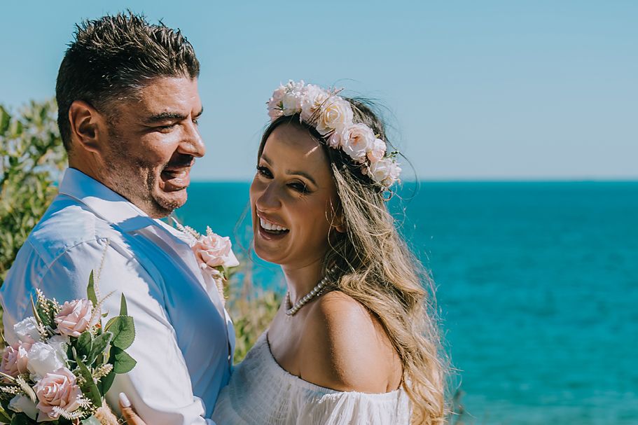 Romantic beach wedding photos with turquoise ocean backdrop and pink floral decorations.