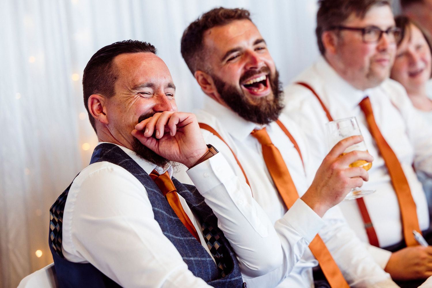 People enjoying a lively social gathering at a restaurant with tables full of drinks and laughter.