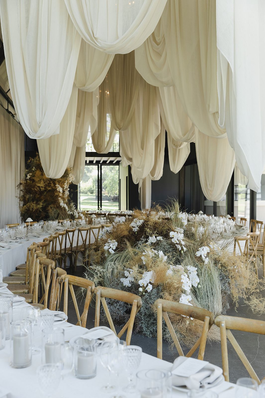 Refined wedding table décor with candles and organic floral accents.