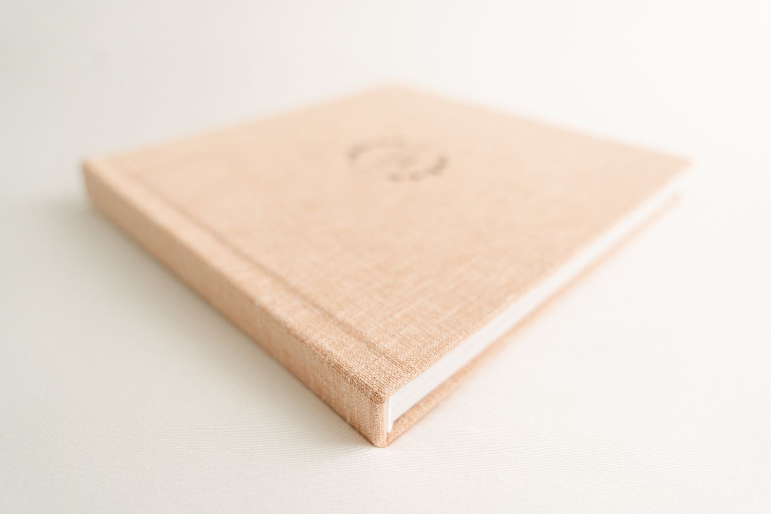Multiple views of a peach-colored hardcover book lying on a white surface showing different angles and perspectives.