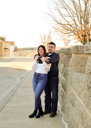 A series of casual engagement photos taken against a stone wall during sunset.