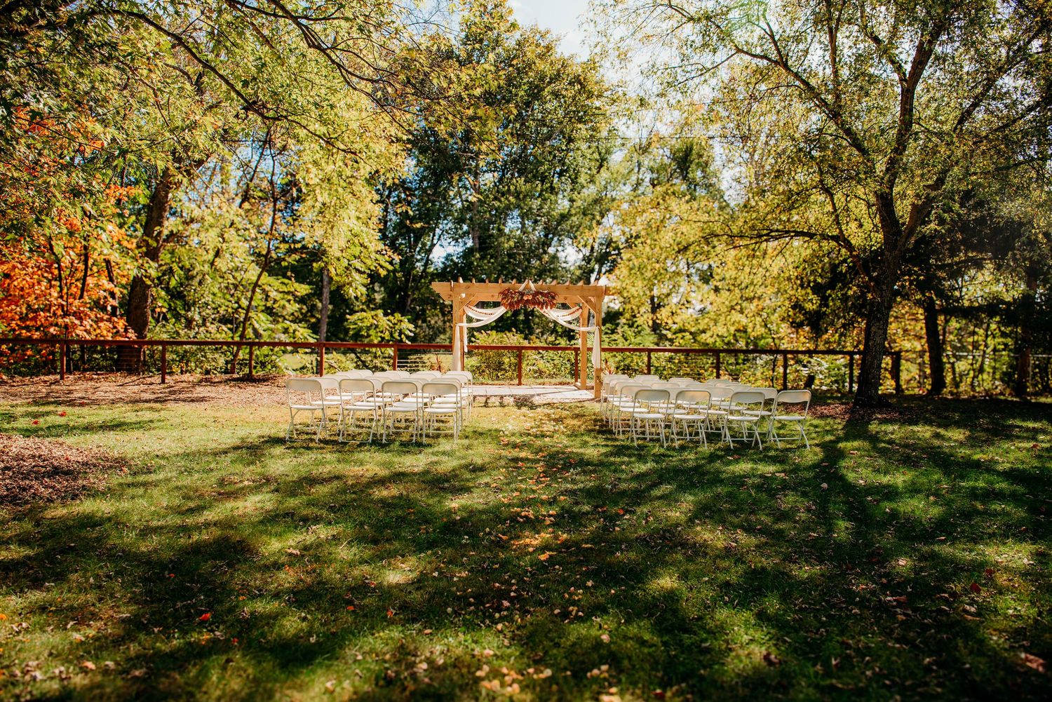 Wedding couple embracing in front of a white garden gazebo during an outdoor ceremony at the Appalachian Wedding Chapel.