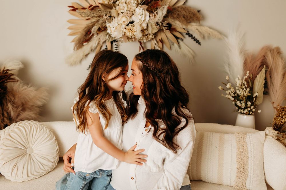 A romantic couple shares tender moments in a neutral-toned room decorated with dried pampas grass and boho decor.